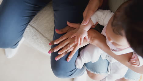 Mother-With-Daughter-And-Baby-Granddaughter-From-Multi-Generation-Family-Comparing-Hand-Sizes