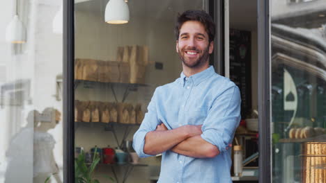 Portrait-Of-Male-Owner-Standing-Outside-Coffee-Shop