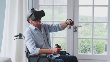 Senior-Disabled-Man-In-Wheelchair-At-Home-Wearing-Virtual-Reality-Headset-Holding-Gaming-Controllers
