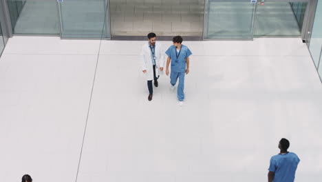 Overhead-View-Of-Medical-Staff-Walking-Through-Lobby-Of-Modern-Hospital-Building