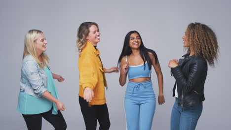 Group-Studio-Shot-Of-Young-Multi-Cultural-Female-Friends-Dancing-Together-In-Slow-Motion