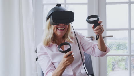 Reife-Behinderte-Frau-Im-Rollstuhl-Zu-Hause-Mit-Virtual-Reality-Headset-Gaming-Controllern