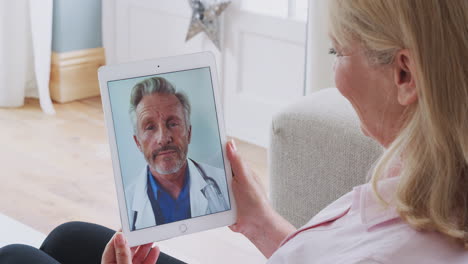 Mature-Woman-Having-Online-Consultation-With-Doctor-At-Home-On-Digital-Tablet