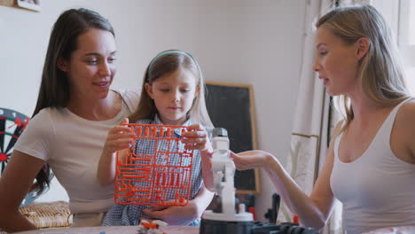 Same-Sex-Female-Couple-Making-Robot-From-Kit-With-Daughter-At-Home-Together