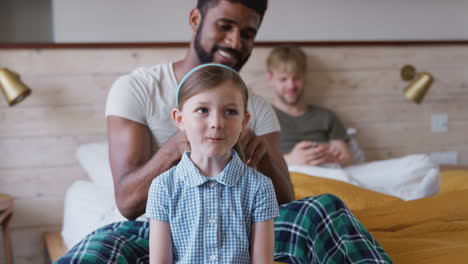 Same-Sex-Male-Couple-At-Home-Getting-Daughter-Ready-For-School-Plaiting-Her-Hair