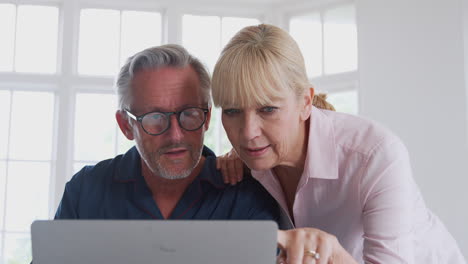 Älteres-Paar-Mit-Mann-Im-Rollstuhl,-Der-Online-Mit-Einem-Laptop-Nach-Informationen-über-Medikamente-Sucht