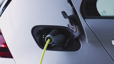 Close-Up-Of-Power-Cable-Charging-Environmentally-Friendly-Zero-Emission-Electric-Car-In-Garage