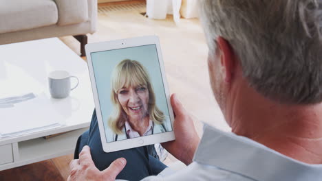 Reifer-Mann,-Der-Zu-Hause-Eine-Online-Konsultation-Mit-Einer-Ärztin-Auf-Einem-Digitalen-Tablet-Durchführt