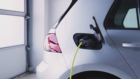 Close-Up-Of-Power-Cable-Charging-Environmentally-Friendly-Zero-Emission-Electric-Car-In-Garage
