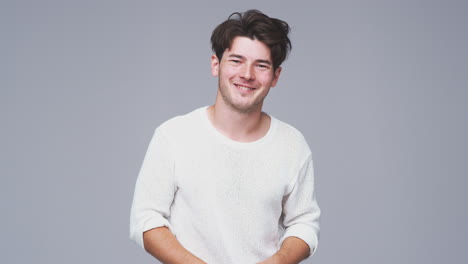 Wide-Angle--Studio-Shot-Of-Young-Man-Smiling-At-Camera-In-Slow-Motion