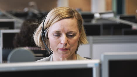 Reife-Geschäftsfrau-Trägt-Telefon-Headset-Und-Spricht-Mit-Anrufer-In-Der-Kundendienstabteilung