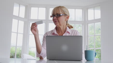 Reife-Frau-Zu-Hause-Sucht-Online-Mit-Laptop-Nach-Informationen-über-Medikamente