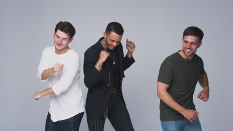 Group-Studio-Portrait-Of-Multi-Cultural-Male-Friends-Dancing-In-Slow-Motion-Together