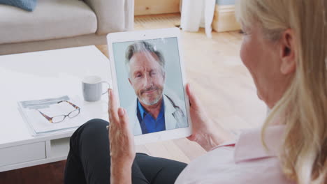 Reife-Frau,-Die-Zu-Hause-Auf-Einem-Digitalen-Tablet-Eine-Online-Konsultation-Mit-Einem-Arzt-Durchführt