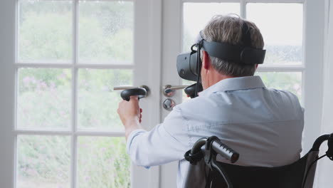 Älterer-Behinderter-Mann-Im-Rollstuhl-Zu-Hause-Mit-Virtual-Reality-Headset-Und-Gaming-Controllern