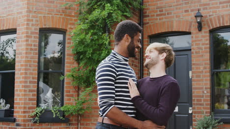 Portrait-Of-Gay-Male-Couple-Standing-Outside-New-Home-On-Moving-Day-Together-Kissing