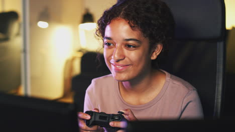 Teenage-Girl-Sitting-In-Chair-In-Front-Of-Screen-At-Home-Holding-Computer-Controller-And-Gaming