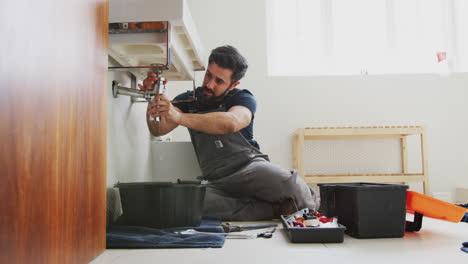 Männlicher-Klempner-Arbeitet-Daran,-Ein-Undichtes-Waschbecken-Im-Heimischen-Badezimmer-Zu-Reparieren