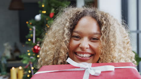 Woman-Carrying-Pile-Of-Christmas-Presents-Walking-Into-Focus-Towards-Camera