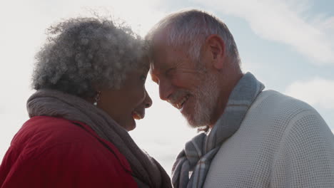 Kopf-an-Kopf-Aufnahme-Eines-Liebenden-älteren-Paares,-Das-Im-Freien-Gegen-Die-Flackernde-Sonne-Spaziert