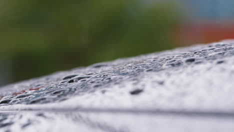 Macro-Close-Up-Shot-Of-Raindrops-Falling-On-Car-In-Slow-Motion