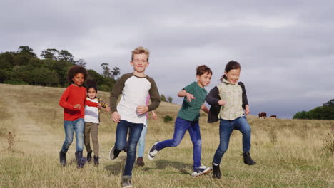 Front-View-Of-Group-Of-Children-On-Outdoor-Activity-Camping-Trip-Running-Down-Hill