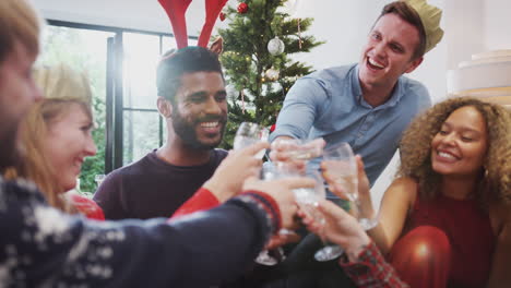 Group-Of-Friends-Celebrating-With-Champagne-After-Enjoying-Christmas-Dinner-At-Home
