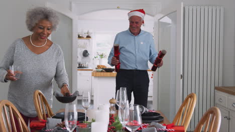 Älteres-Paar-Zu-Hause-Decken-Und-Dekorieren-Den-Tisch-Für-Das-Essen-Am-Weihnachtstag