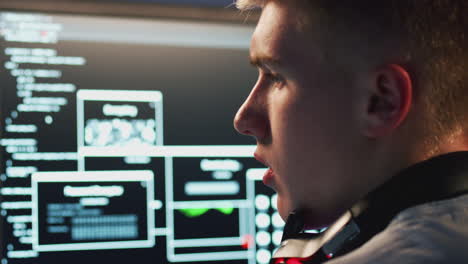 Male-Teenage-Hacker-Sitting-In-Front-Of-Computer-Screens-Bypassing-Cyber-Security