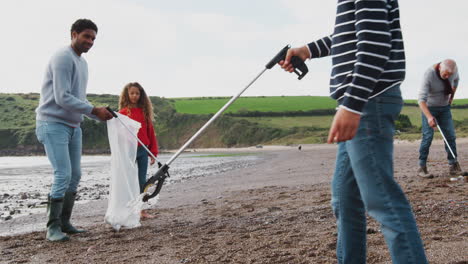 Multi-Generation-Family-Collecting-Litter-On-Winter-Beach