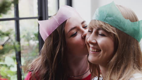 Gay-Female-Couple-Having-Fun-At-Home-Hanging-Decorations-On-Christmas-Tree-Together