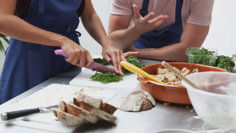 Close-Up-Of-Woman-Chopping-Fresh-Herbs-For-Dish-In-Kitchen-Cookery-Class