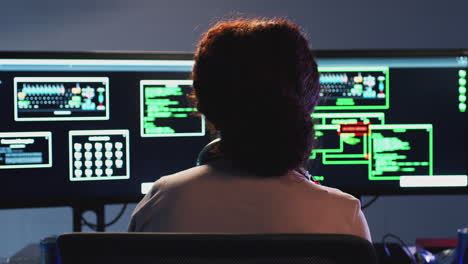 Rückansicht-Einer-Jugendlichen-Hackerin,-Die-Vor-Computerbildschirmen-Sitzt-Und-Die-Cybersicherheit-Umgeht