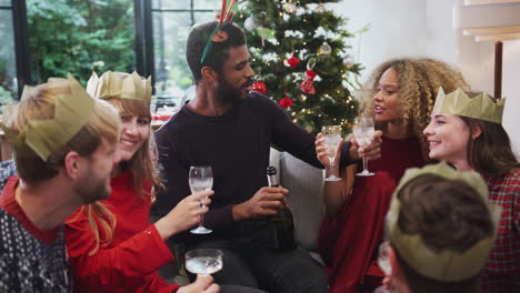 Gruppe-Von-Freunden,-Die-Mit-Champagner-Feiern,-Nachdem-Sie-Das-Weihnachtsessen-Zu-Hause-Genossen-Haben