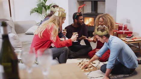 Group-Of-Friends-Playing-Board-Games-After-Enjoying-Christmas-Dinner-At-Home