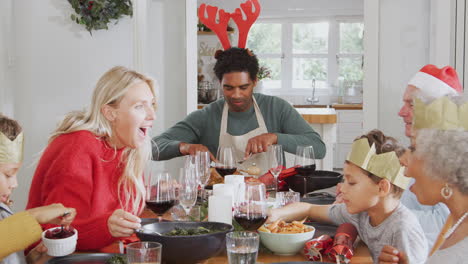 Multi-Generation-Family-Sitting-At-Dining-Table-Enjoying-Christmas-Meal-At-Home-Together