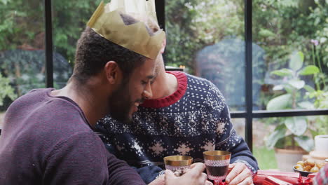 Homosexuelles-Männliches-Paar-Sitzt-Zum-Weihnachtsessen-Am-Tisch-Und-Redet-Und-Stößt-An