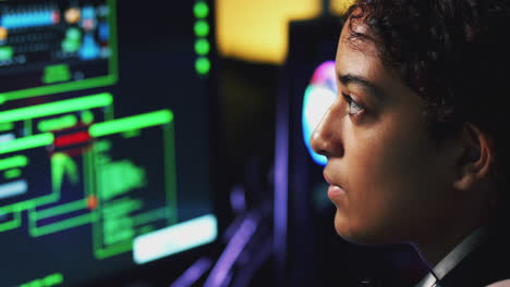 Female-Teenage-Hacker-Sitting-In-Front-Of-Computer-Screens-Bypassing-Cyber-Security