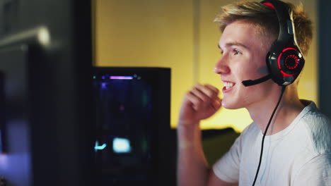 Excited-Teenage-Boy-Wearing-Headset-Winning-At-Gaming-At-Home-Using-Dual-Computer-Screens