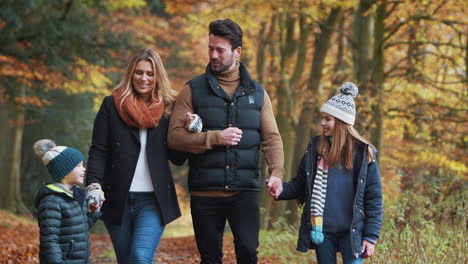 Smiling-Family-Walking-Along-Path-Through-Autumn-Countryside-Together