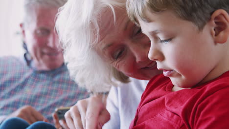 Großeltern-Spielen-Zu-Hause-Videospiele-Mit-Enkelkindern-Auf-Mobiltelefonen