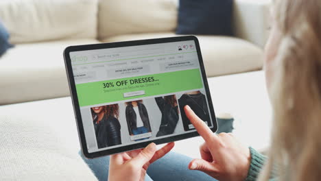 Close-Up-Of-Woman-Shopping-For-Clothes-Online-Using-App-On-Digital-Tablet