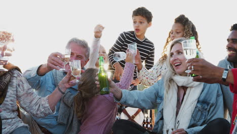 Multi-Generation-Family-Making-A-Toast-With-Alcohol-On-Winter-Beach-Vacation