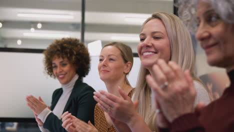 Line-Of-Businesswomen-In-Modern-Office-Applauding-Presentation-By-Colleague