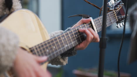 Nahaufnahme-Einer-Musikerin,-Die-Draußen-Auf-Der-Straße-Akustikgitarre-Spielt