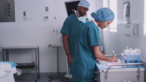 Equipo-Quirúrgico-Revisando-La-Documentación-Del-Paciente-En-El-Quirófano-Del-Hospital.