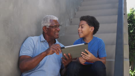 Großvater-Und-Enkel-Sitzen-Zu-Hause-Auf-Stufen-Im-Freien-Und-Nutzen-Ein-Digitales-Tablet