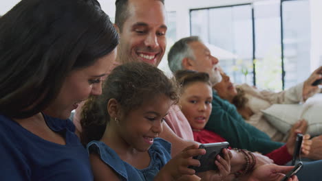 Mehrgenerationenfamilie-Auf-Dem-Sofa-Vor-Dem-Fernseher-Und-Beim-Spielen-Mit-Digitalen-Tablets-Und-Mobiltelefonen