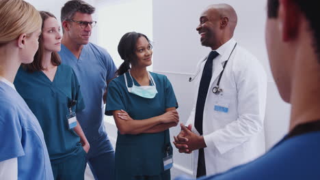 Multi-Cultural-Medical-Team-Having-Meeting-In-Hospital-Corridor