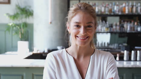 Portrait-Of-Confident-Female-Owner-Of-Restaurant-Bar-Standing-Inside-By-Counter